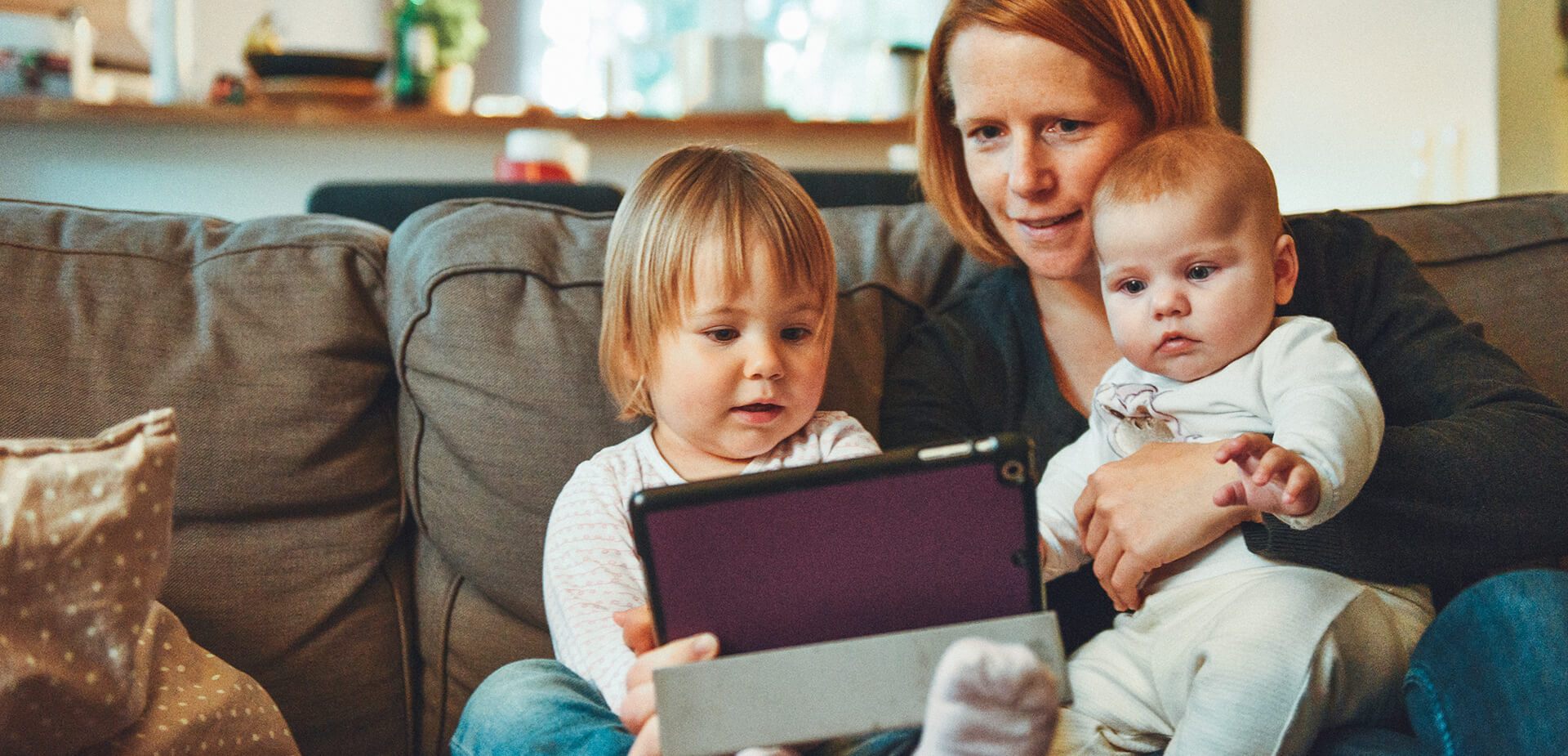 Mère avec ses deux enfants devant une tablette