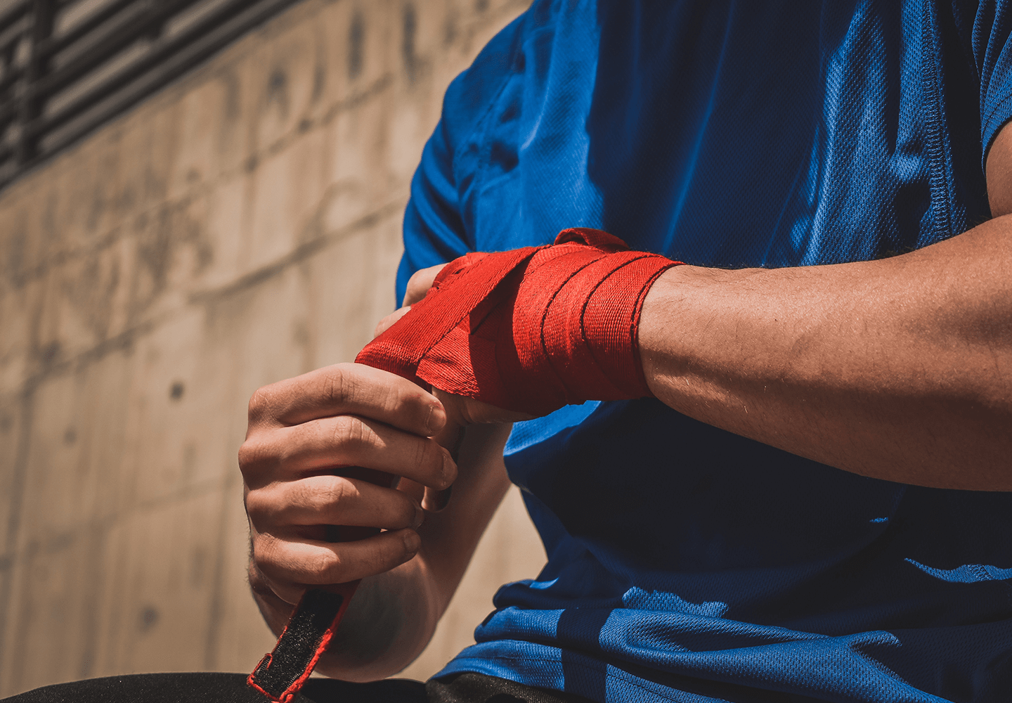 Sportif entourant ses poignets de ruban avant une pratique d'arts martiaux
