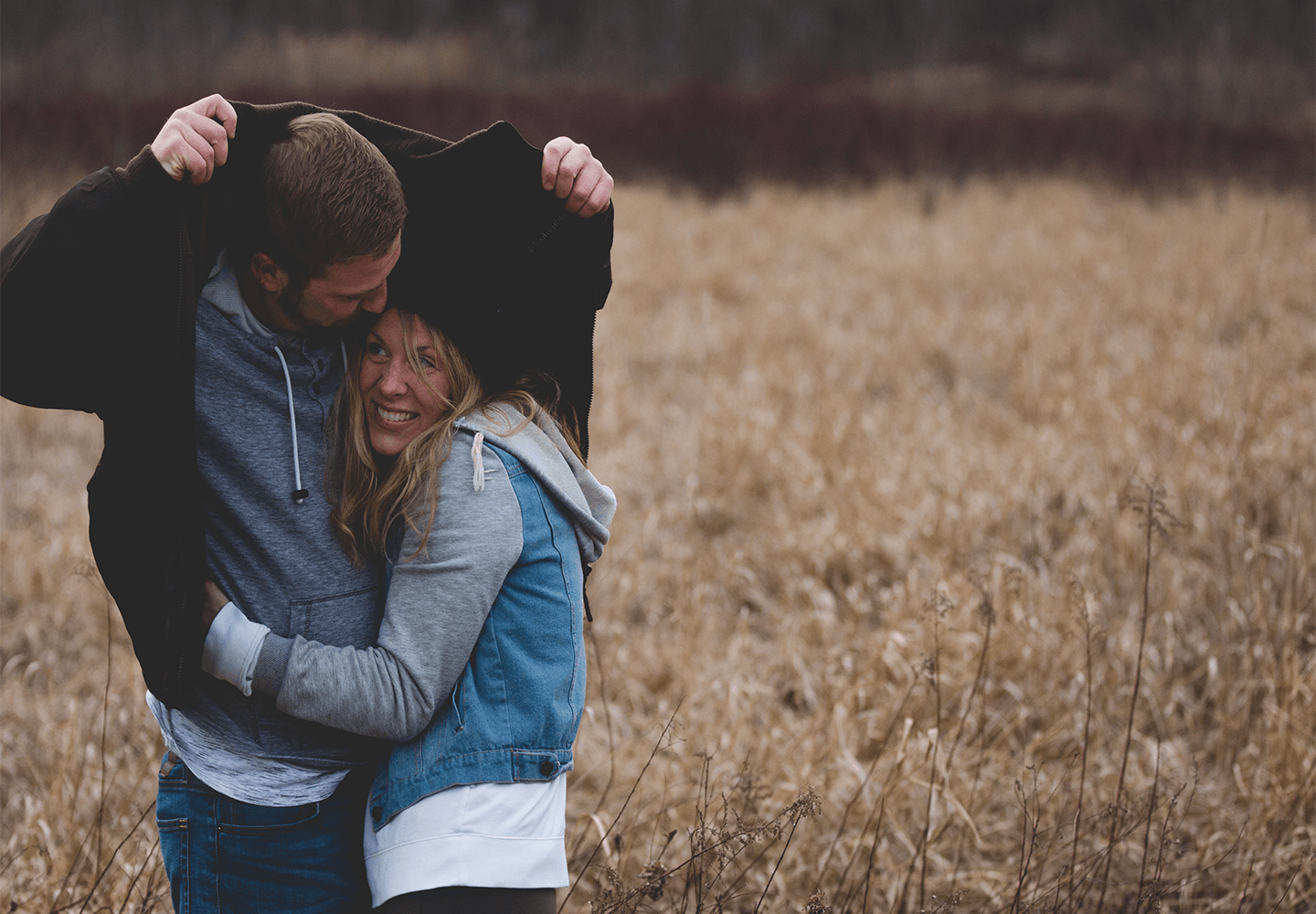 Jeune couple se mettant à l'abris de la pluie