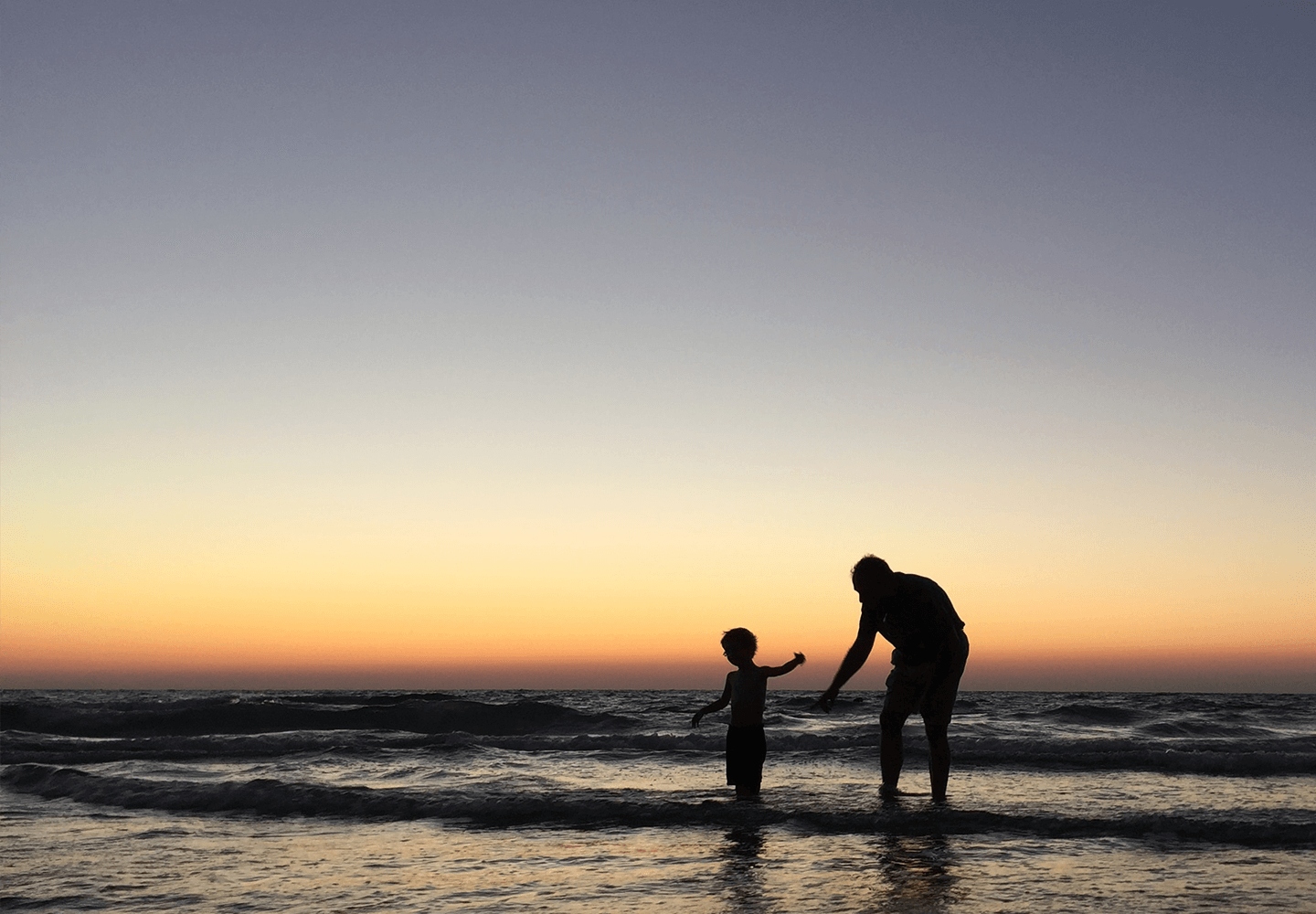 Grand-père et son petit-fils s'amusant sur une plage en vacances